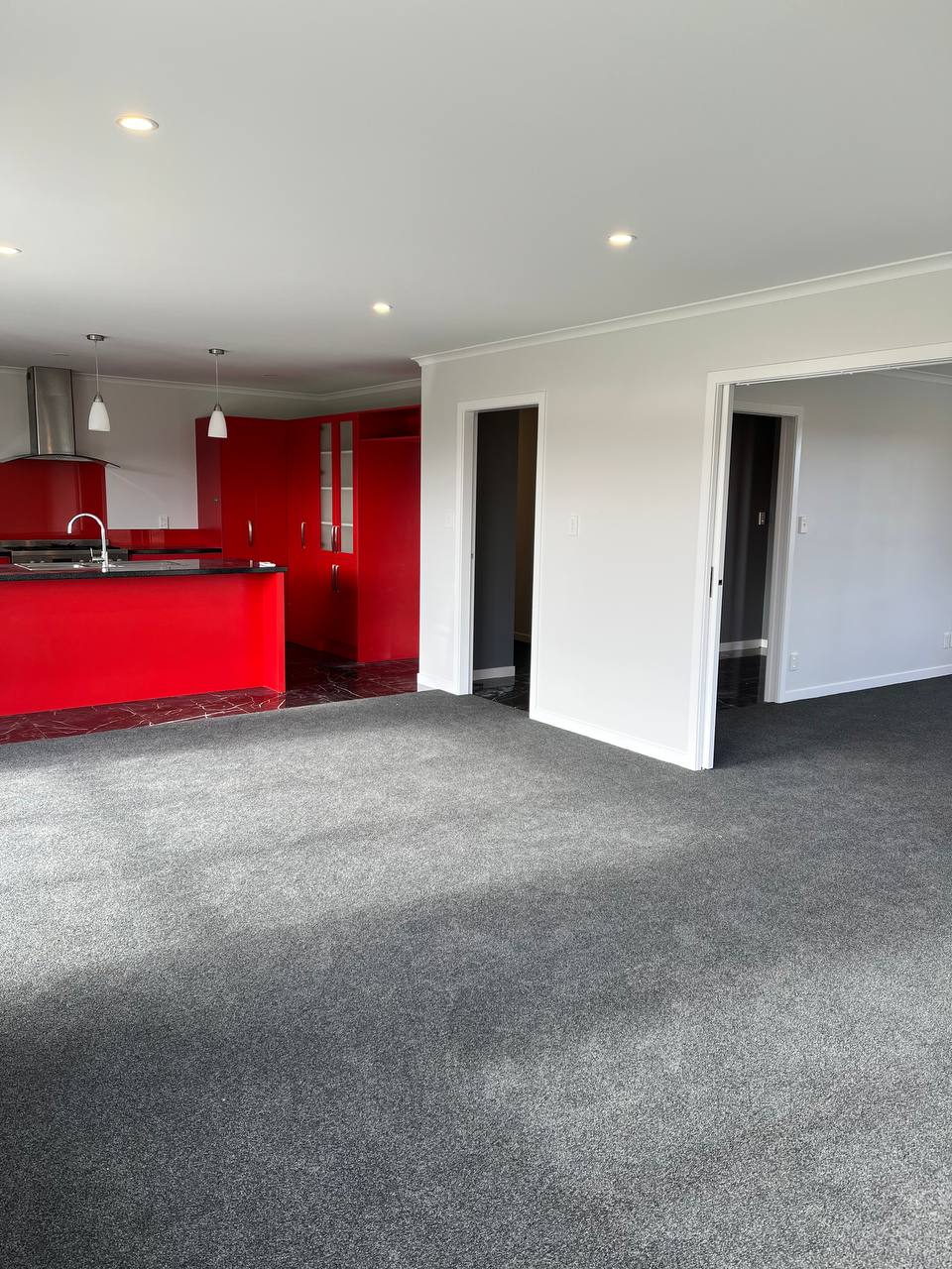 Same living room after full repaint - grey carpet, clean white walls, modern finish