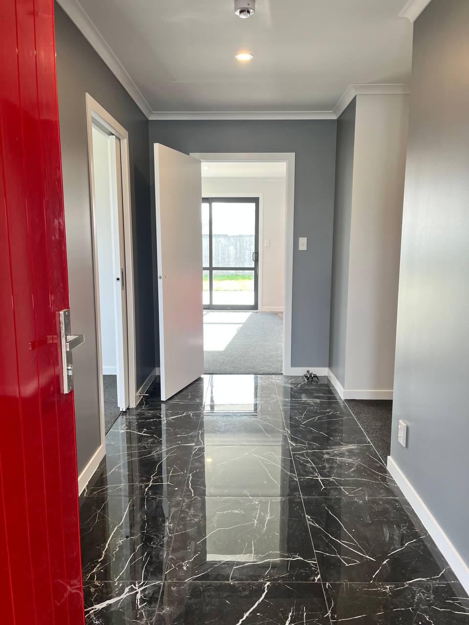 Entry hallway - grey accent walls with polished marble-look tile